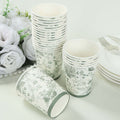Floral-patterned disposable cups stacked with one tipped over on a white background.