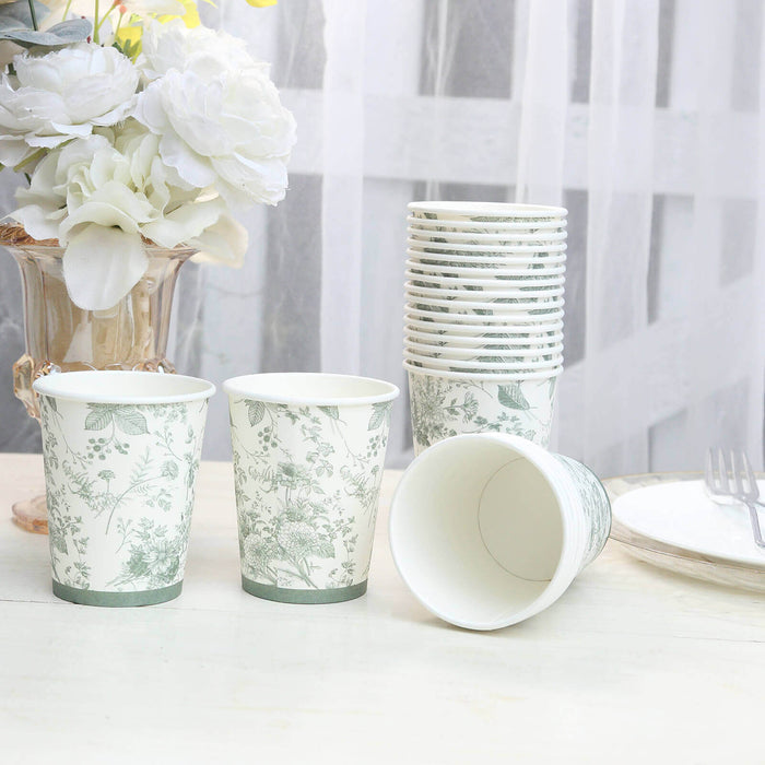 Floral design disposable cups stacked on a table with flowers in the background.