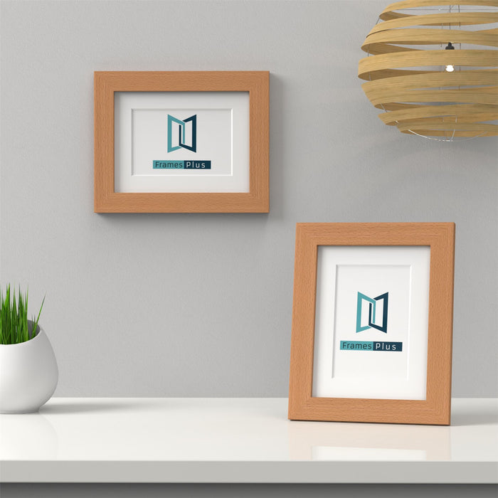 Beech picture frame with white mount displayed on a table beside a plant and pendant light.