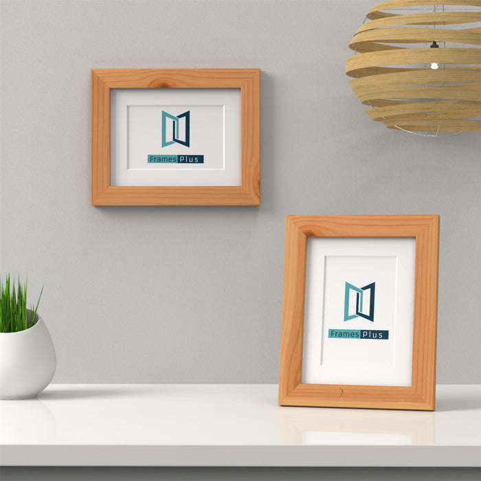 Pine picture frame with white mount showcased on a clean white table with plant decor.