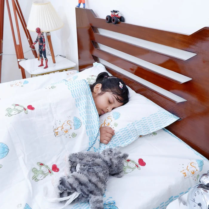 Child sleeping under a hand block print kids dohar featuring playful animal designs and colorful patterns