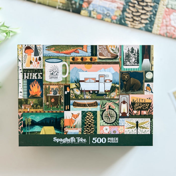 The Spaghetti Tree “Let’s Go Camping” 500 piece jigsaw puzzle features illustrated nature scenes with a camper, tent, animals, trees, and outdoor activities.