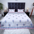 Hand block print cotton bedcover in white with floral patterns and coordinating pillow covers