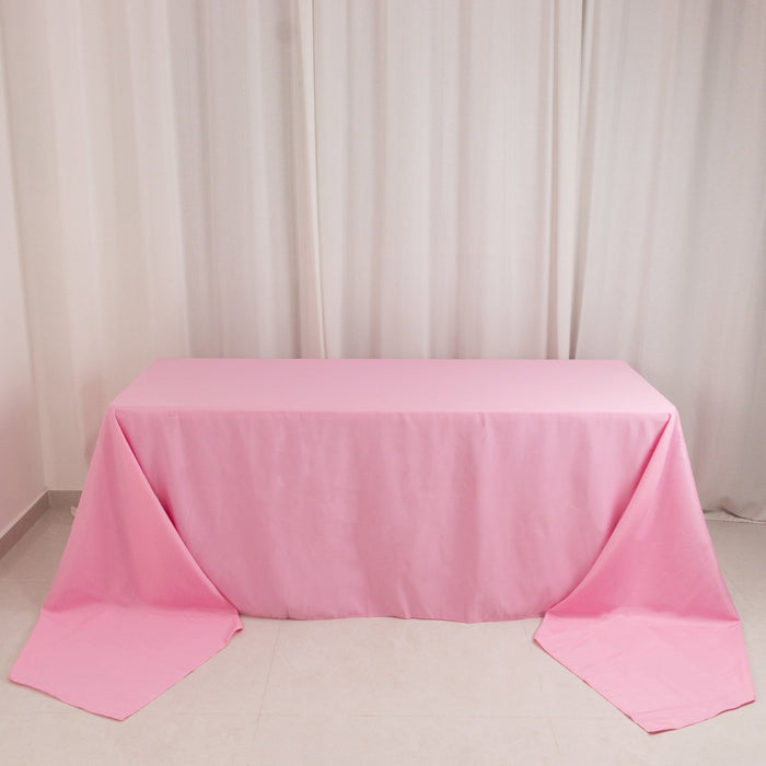Pink tablecloth draped over a table in a minimalist setting.