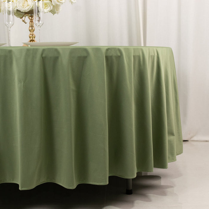 Green tablecloth draped on a round table in an elegant setting.