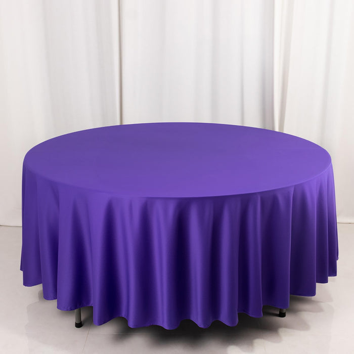 Purple round tablecloth on a white backdrop.